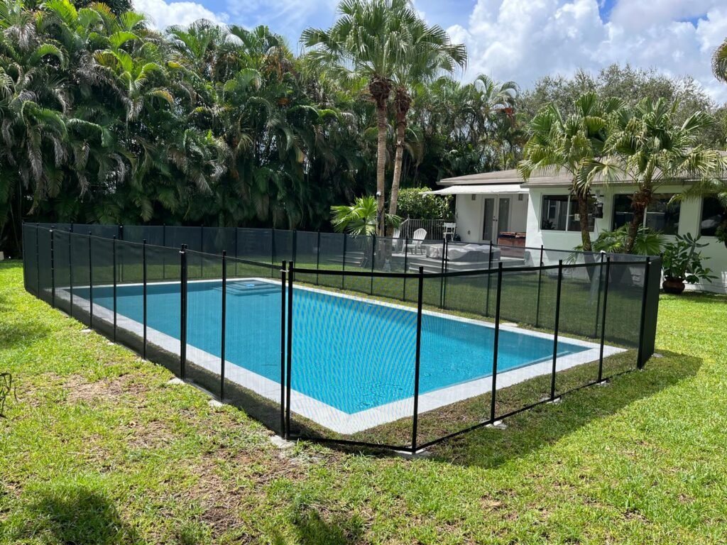 Black mesh pool safety fence installed around a backyard swimming pool in the Fort Myers, FL area