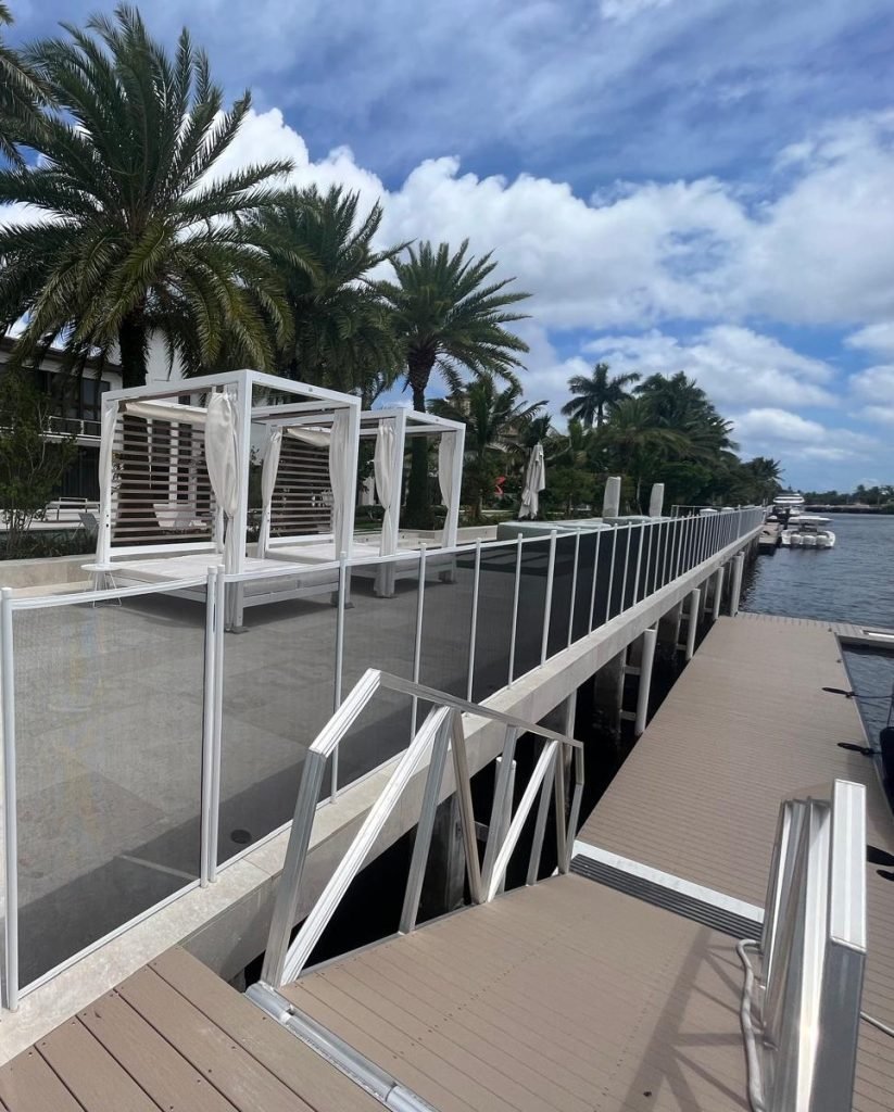 Waterfront Pool Safety Fence Installation in Boca Raton, FL White removable pool safety fence installed along a luxury waterfront property in Boca Raton, Florida