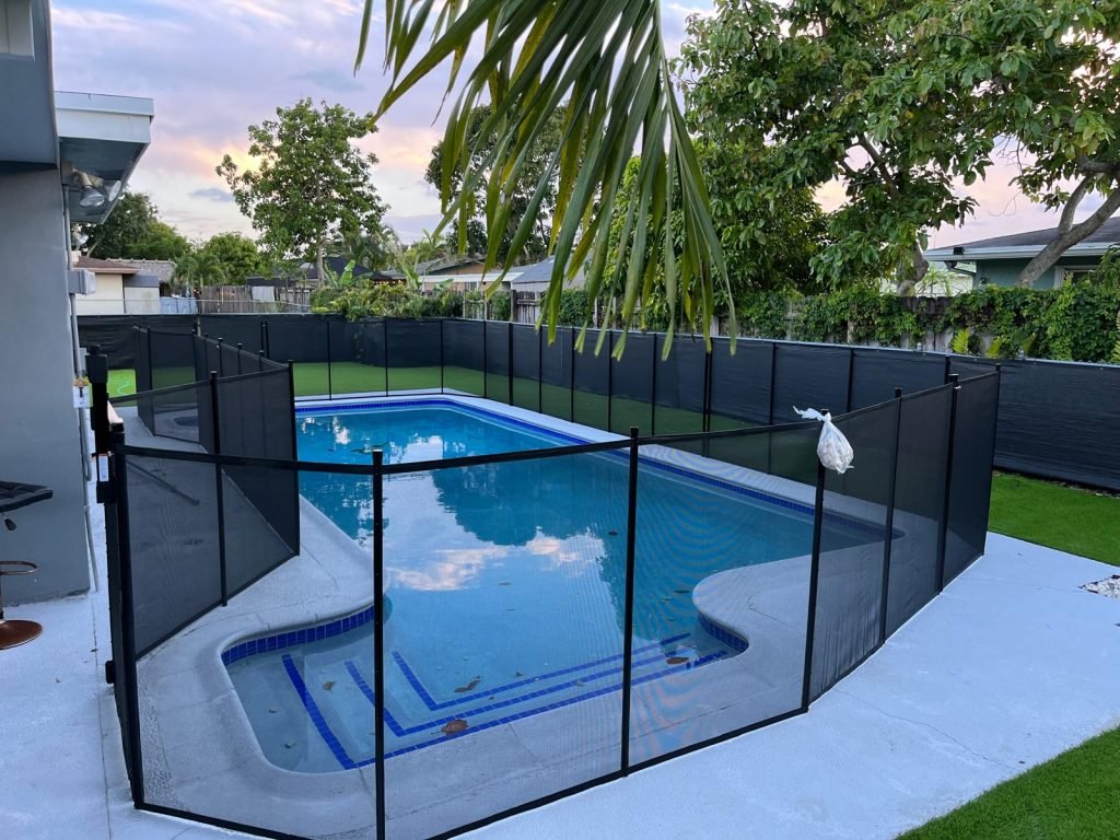 Pembroke Pines Black Mesh Pool Safety Fence Installation Black removable mesh pool safety fence installed around a backyard swimming pool in Pembroke Pines, FL.